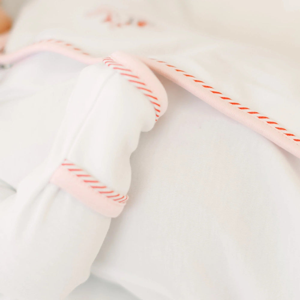 That Store girls footie in soft white cotton with delicate pink picot trim and red embroidered ribbon details.