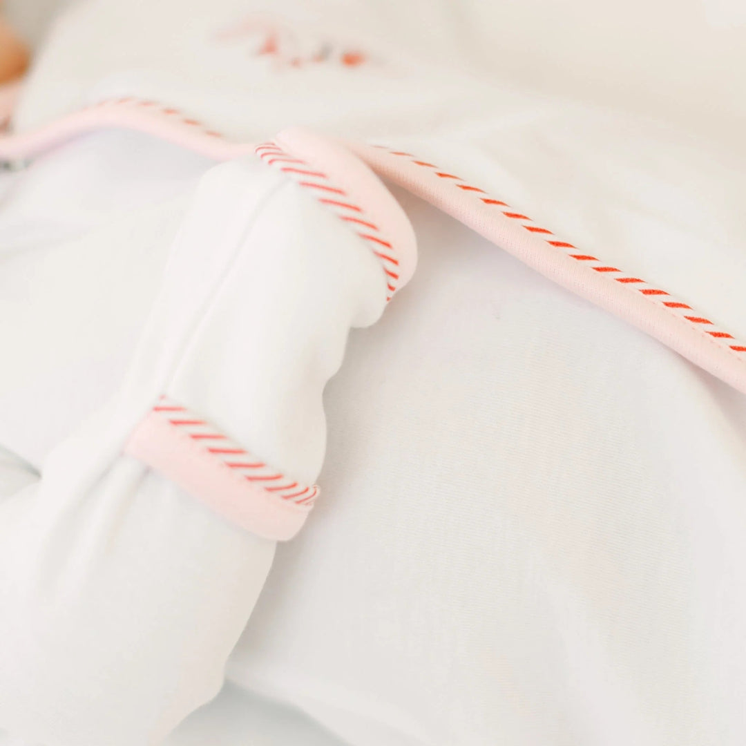That Store girls footie in soft white cotton with delicate pink picot trim and red embroidered ribbon details.