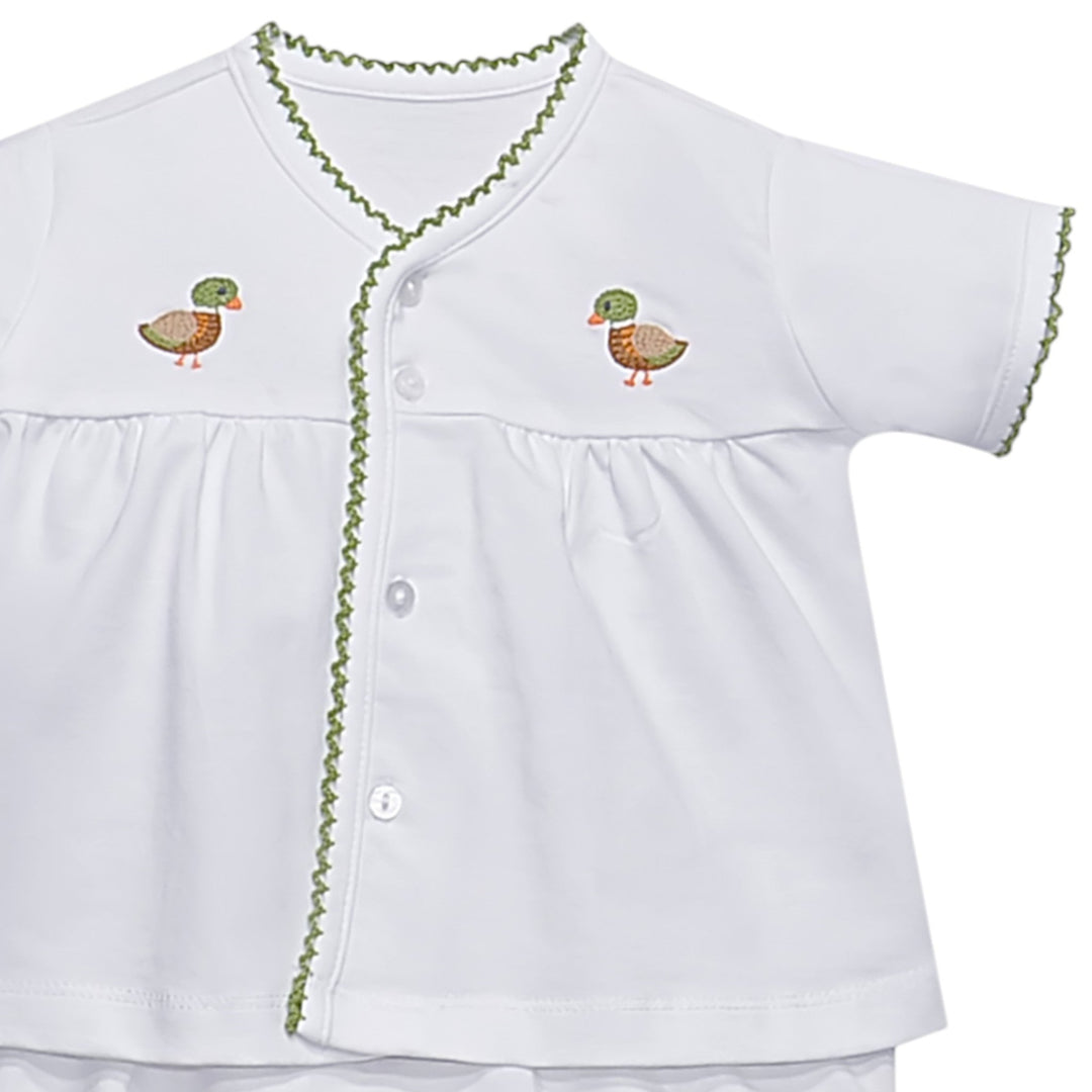 That Store white unisex diaper set featuring a button-down top with green scalloped trim and embroidered duck motifs.