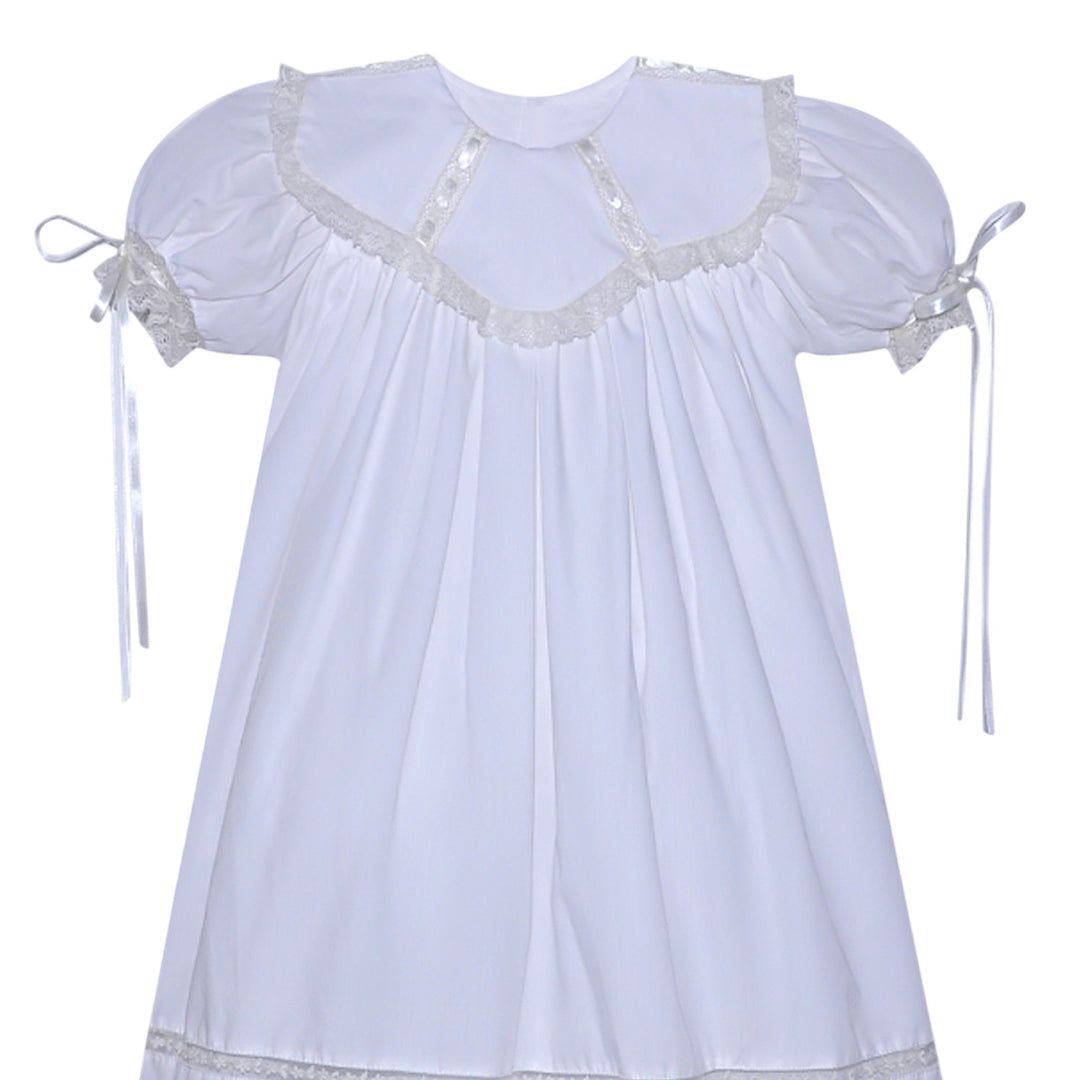 That Store white heirloom dress with ecru lace trim, puff sleeves, and ribbon ties for special occasions.