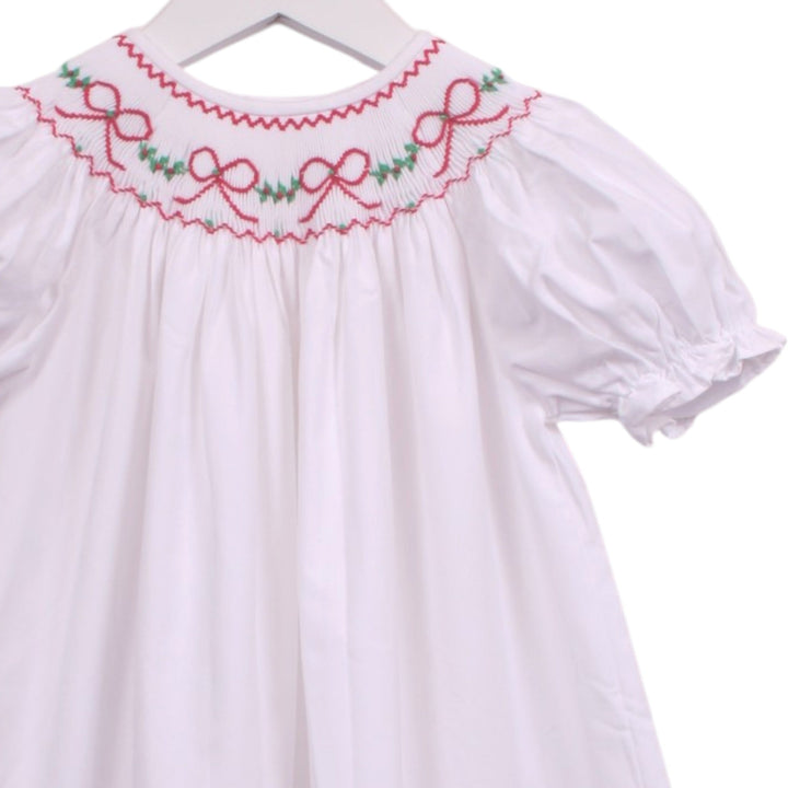 That Store white bishop dress with smocked neckline featuring red bows and green garland embroidery