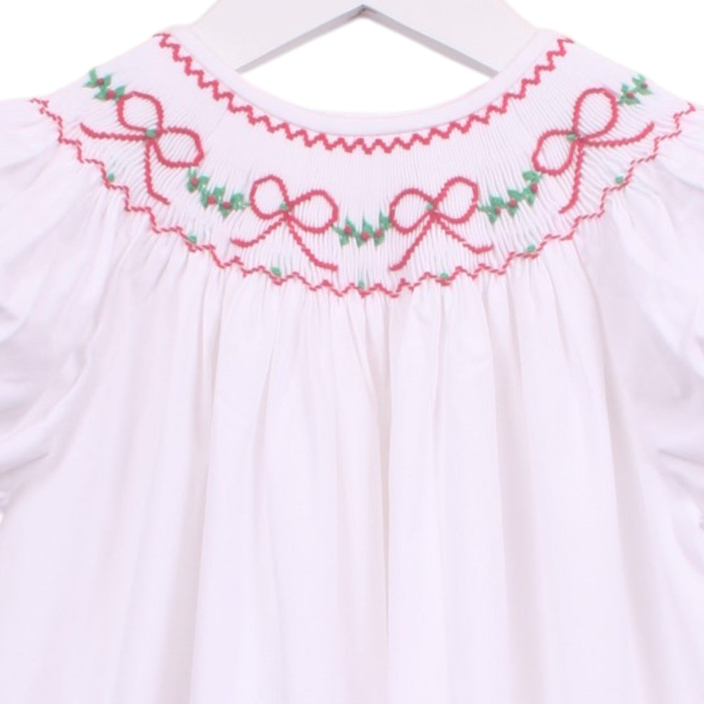 That Store white bishop dress with smocked neckline featuring red bows and green garland embroidery