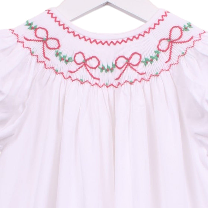 That Store white bishop dress with smocked neckline featuring red bows and green garland embroidery