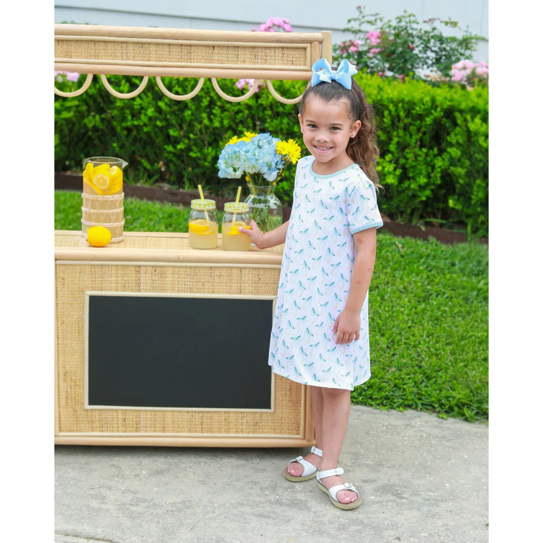 That Store Squeeze the Day yellow lemon print cotton dress worn by a young girl with a blue hair bow